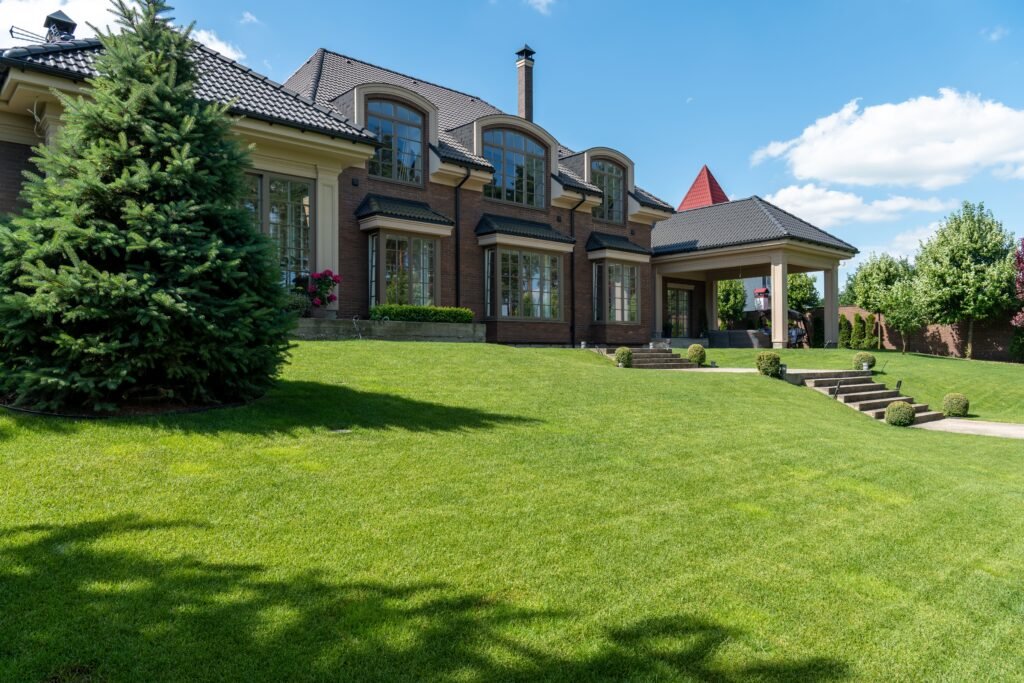 Luxury estate with manicured lawn and modern architectural design on a sunny day.